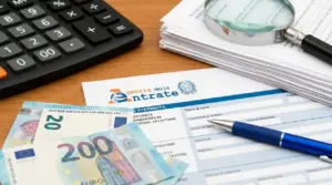 Moduli fiscali con banconote in euro, penna, calcolatrice e lente su scrivania, per nuovi controlli fiscali